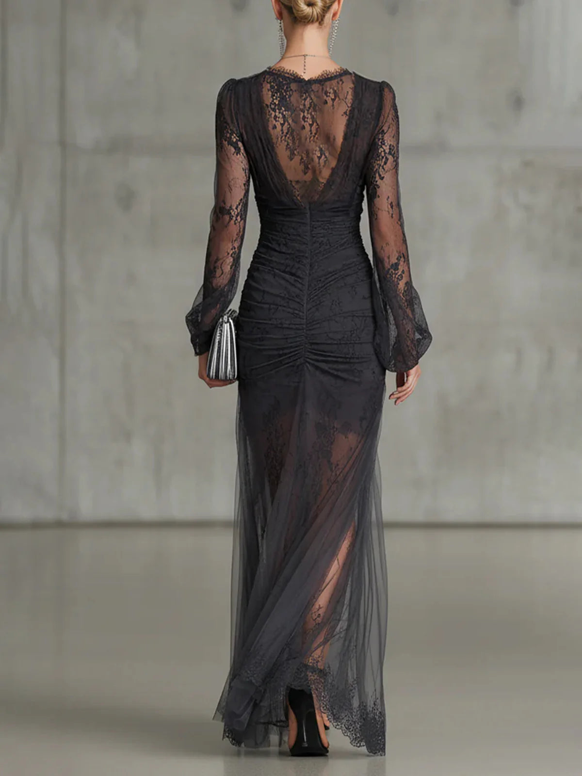Vestido largo de encaje gris oscuro con volantes, transparencias, mangas largas y sensual abertura lateral