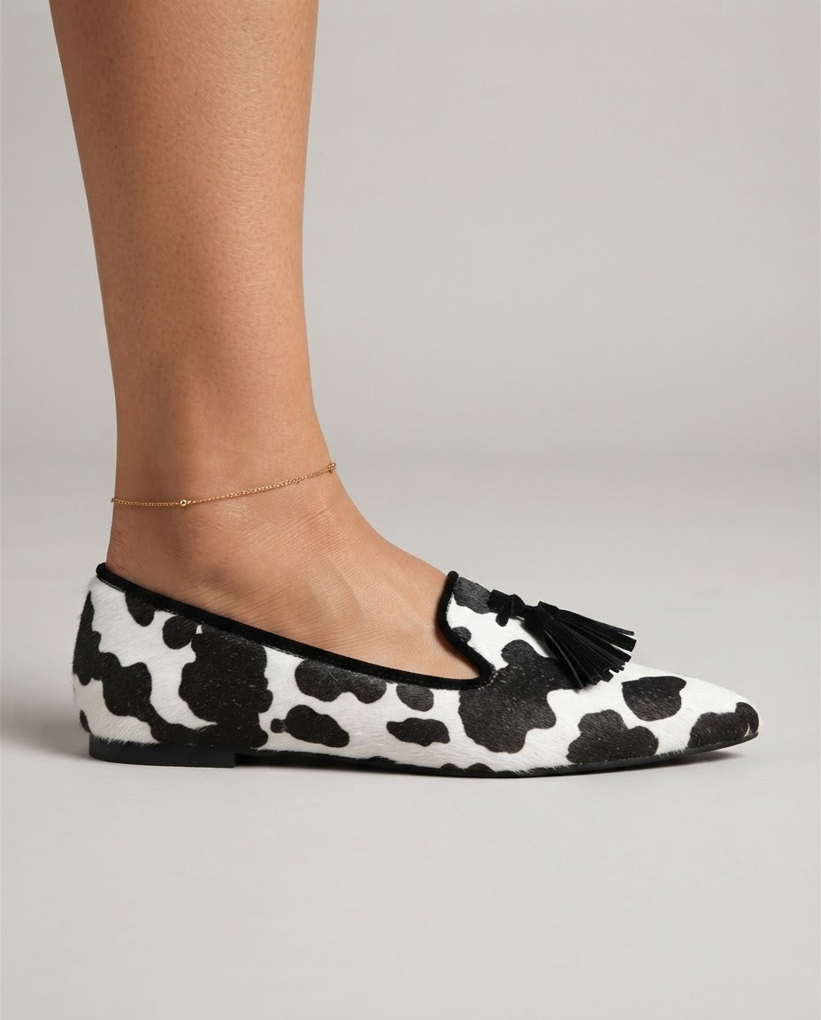 Mocasín Ginevra — Elegante estampado de piel de vaca en blanco y negro con borlas negras