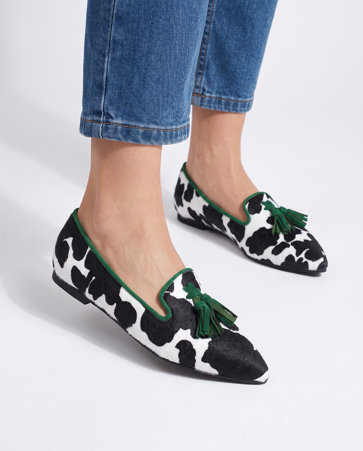 Mocasín Ginebra de piel de vaca en blanco y negro con elegantes borlas verdes