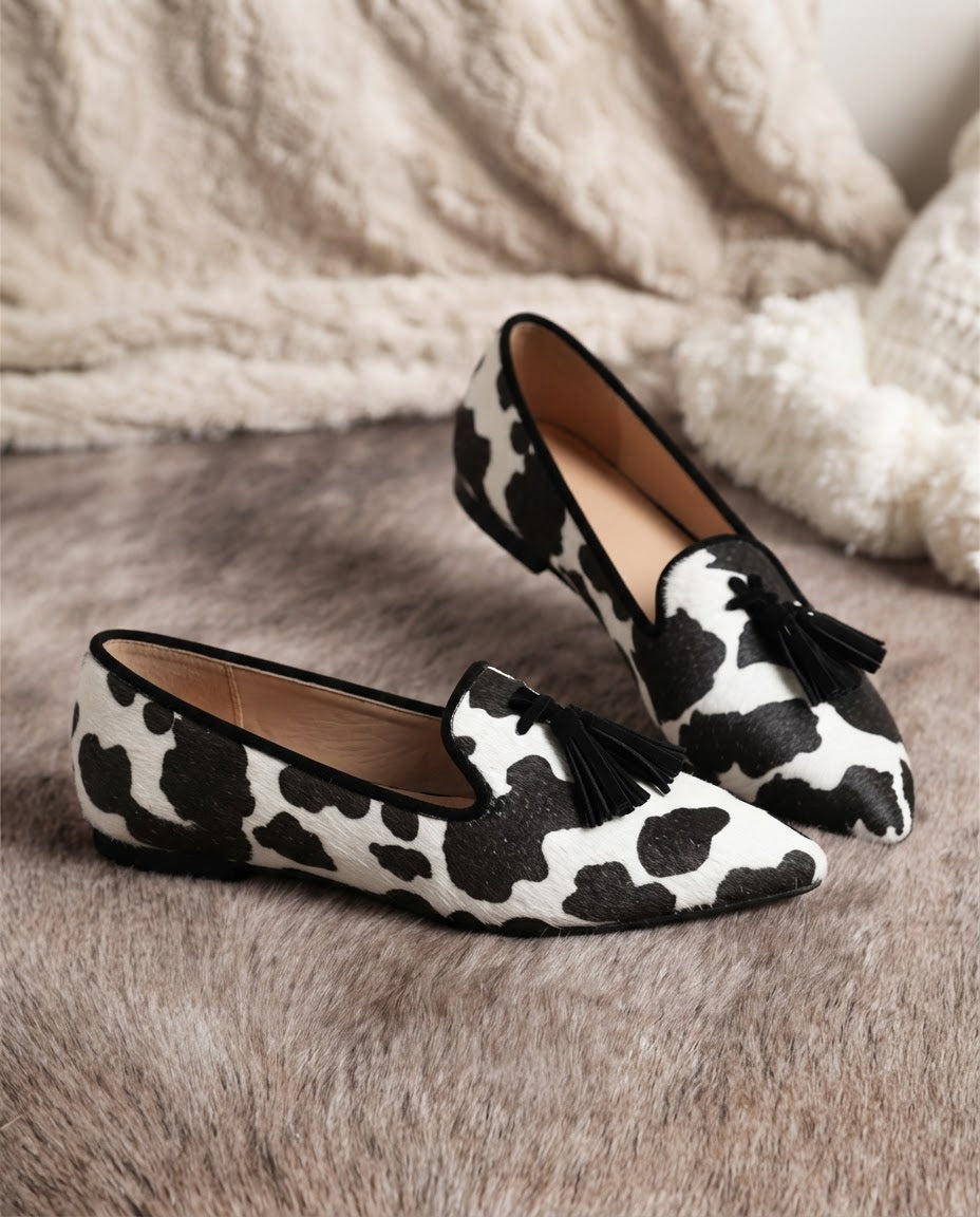 Mocasín Ginevra — Elegante estampado de piel de vaca en blanco y negro con borlas negras